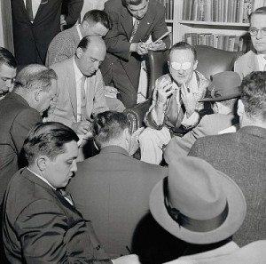17 May 1956 --- Original caption: Newsmen interview columnist-victim of acid thrower. New York, New York: Labor columnist Victor Riesel, blinded by an unknown assailant who threw acid into his eyes, is shown at St. Claire's Hospital as he met newsmen for the first time since he was hospitalized. Riesel appears to be describing to the reporters how the acid was thrown at him. --- Image by © Bettmann/CORBIS
