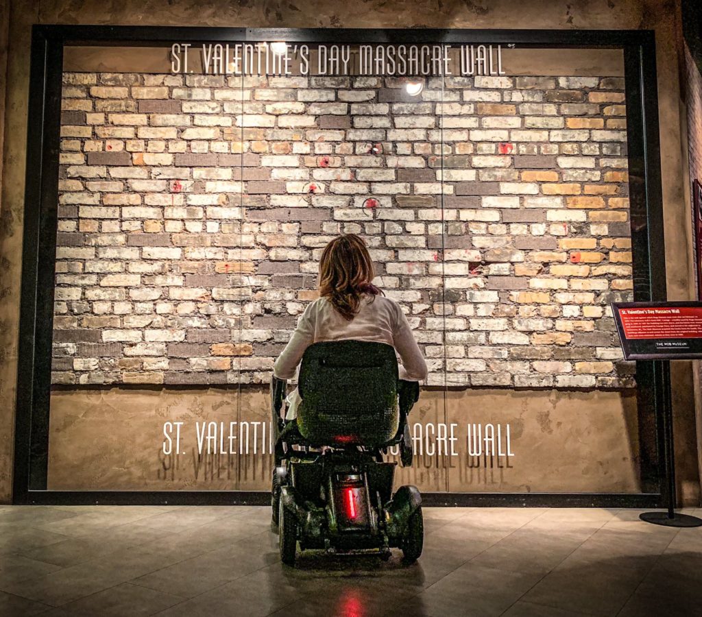 Person in wheelchair viewing St. Valentines Day Massacre Wall