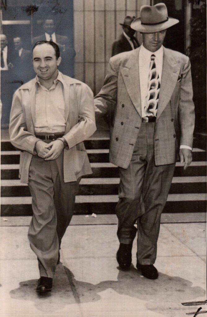 Jewish mobster Mickey Cohen smiles for the camera after leaving federal court in 1951. Cohen was convicted of tax evasion. Courtesy of J. Michael Niotta