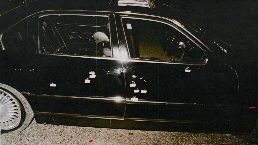 A crime scene photo shows the passenger side of the black BMW riddled with bullet holes. Las Vegas Metropolitan Police Department