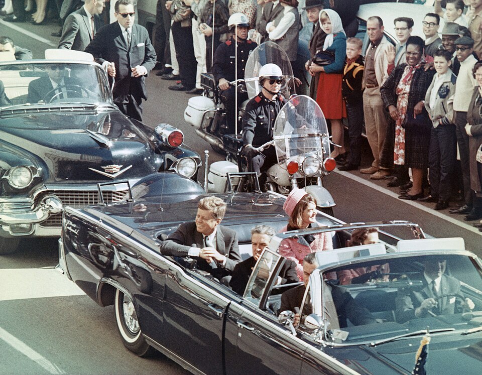 On November 22, 1963, President John F. Kennedy was shot and killed while traveling in a presidential motorcade alongside his wife, Jacqueline. Public domain