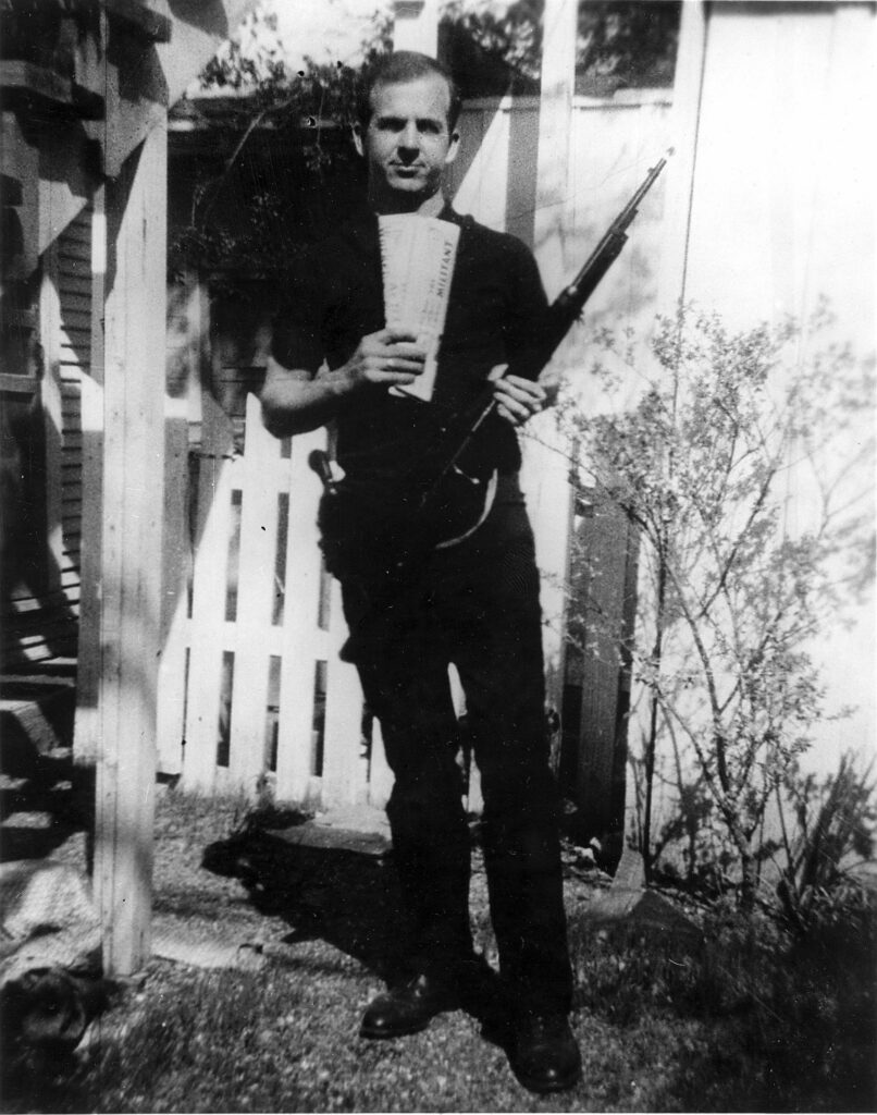 Lee Harvey Oswald is a central figure in many of the JFK assassination conspiracy theories. In this photo, Oswald holds two socialist and communist newspapers and a Carcano rifle that matches the description of the firearm found on the sixth floor of the Texas School Book Depository at Dealey Plaza. Federal Bureau of Investigation